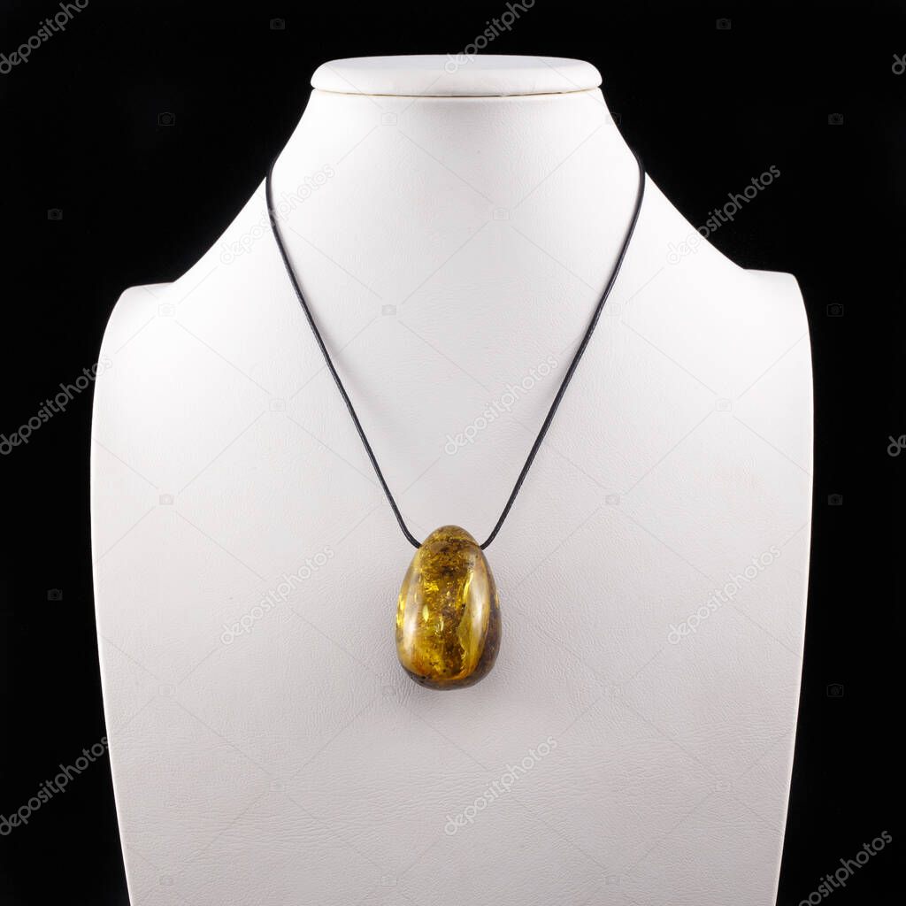 Products and jewelry from amber. Processed amber. Pendant from natural amber on a white background.