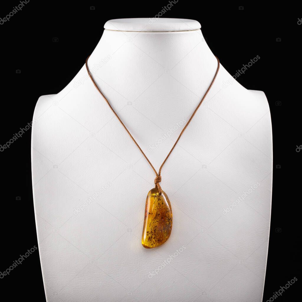 Products and jewelry from amber. Processed amber. Pendant from natural amber on a white background.