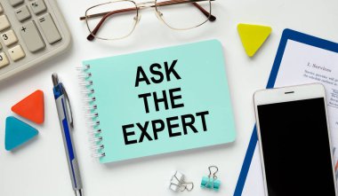 Not defterinde motivasyon teşvik alıntısı yazıyor. Uzmana sorun. Hesap makinesi, bardaklar ve para masada.