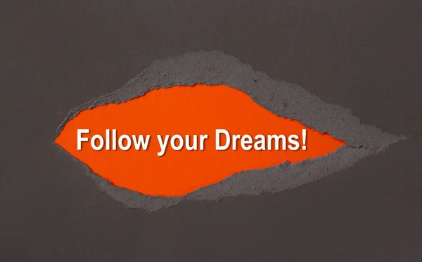 追随你的梦想 出现在撕破的褐色纸后面 动机鼓励引证 — 图库照片