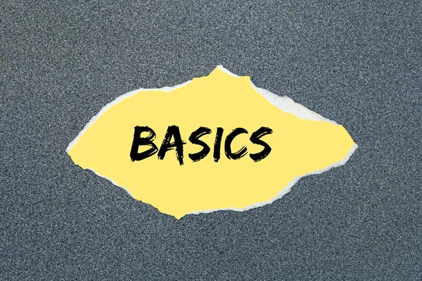 Yırtık sarı kağıda yazılmış BASICS. Gri arkaplan