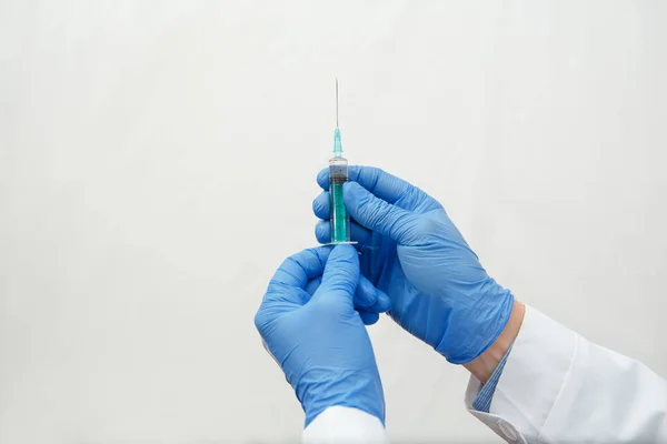 Doctor in gloves holding a medical injection syringe