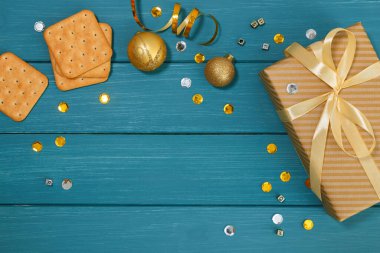 Noel veya yeni yıl kompozisyonu, ahşap mavi arka plan ve altın Noel süslemeleri ve hediyeleri