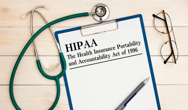 Стол для рабочего стола, ноутбук, очки, ручка и документы с HIPAA Закон о переносе медицинского страхования и подотчетности 1996 года на заголовок