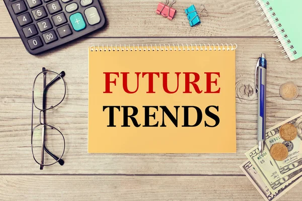 Future trends is written on a notepad, on an office desk with office accessories. Business concept.