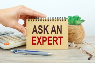İş konsepti - Çalışma masası ve not defteri yazan ASK An Expert