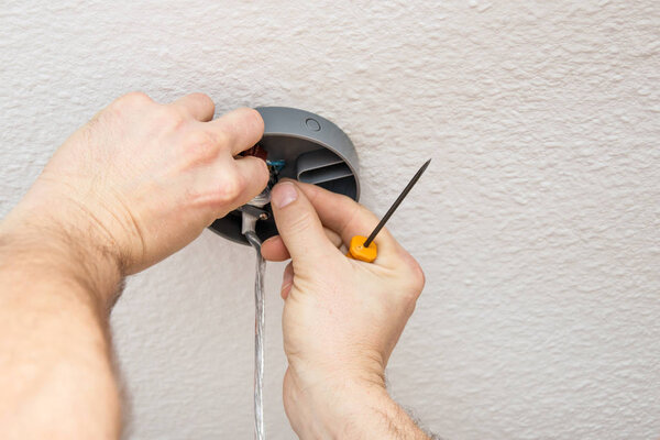 fixing a new chandelier on the ceiling