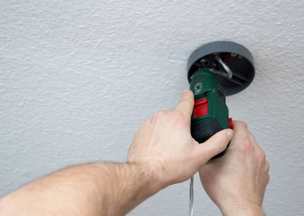 Fixing a new chandelier on the ceiling — Stock Photo, Image