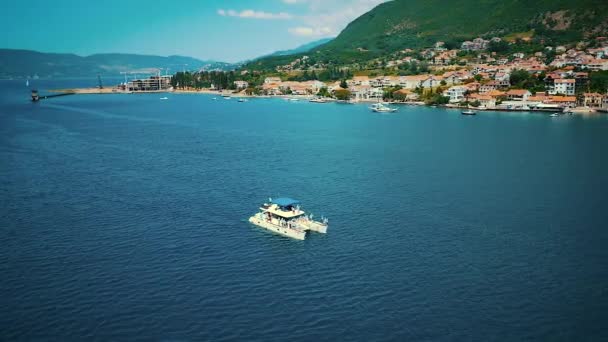 Vista aérea del barco que cruza con los jóvenes en el mar en Montenegro — Vídeos de Stock