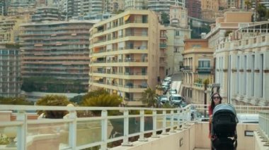 Kadın bir yürüyüşe ile bebek arabası içinde onun bebek gibi toursits Monaco seyahat