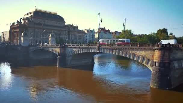 Aerial strzał o rzeki w pobliżu Teatru Narodowego z tramwajem na moście w Praga, Czech Republic — Wideo stockowe