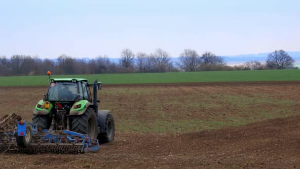 Nelahozeves, República Checa - 27.03.2019: Agricultura. El tractor prepara el terreno para la siembra y el cultivo en Europa. Agronomía, el concepto de agricultura . Vídeo De Stock