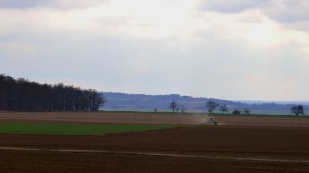 Nelahozeves, Tsjechië - 27.03.2019:Green trekker werken in een tarweveld. Landbouw en milieu in de Europese Unie. Trekker is cultiveren — Stockvideo