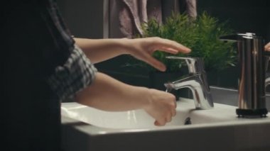 Hijyen temizlik ve banyo, kamera kaydırıcıyı geceleri sıvı sabun ile el yıkama genç kadındır