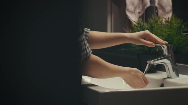 schön asiatische Frau ist waschen Ihr Gesicht in der Nacht im Badezimmer Kamera auf Schieberegler