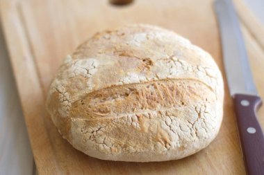 Taze pişmiş ekmek somunları ahşap tahtada ve bıçakla