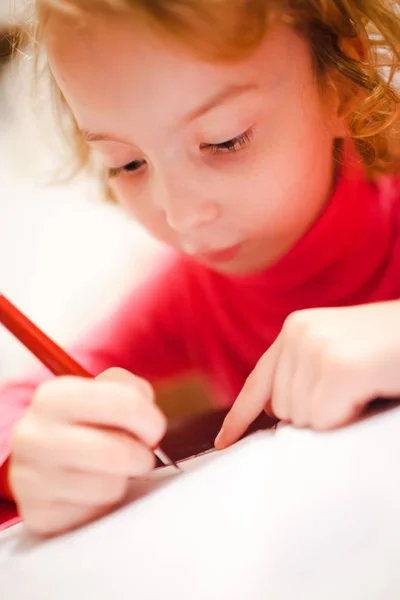 Small girl making her first writing homework.