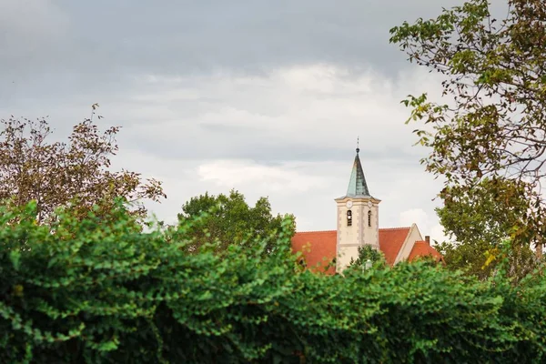 A vörösréz tető - tipikus európai keresztény egyház templomtorony. — Stock Fotó