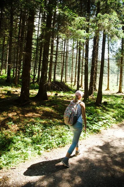 A woman walking on forest road during summer vocation - keep in shape.