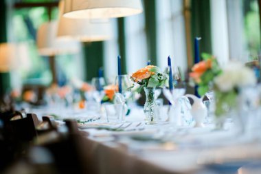 Düğün masa turuncu, yeşil ve mavi renklerde dekore edilmiş.