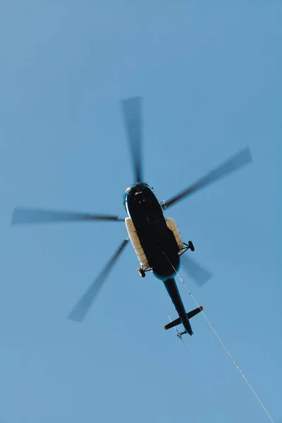 Cargo helicopter with suspended freight on cable - in action — Stock Photo, Image