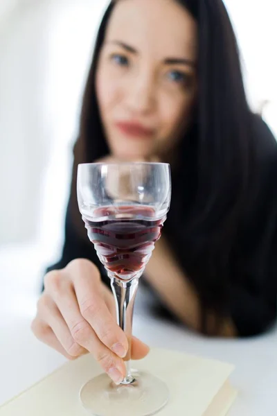 Vino rosso in mano di donna attraente sdraiato sul letto - Vetro di cristallo . — Foto Stock