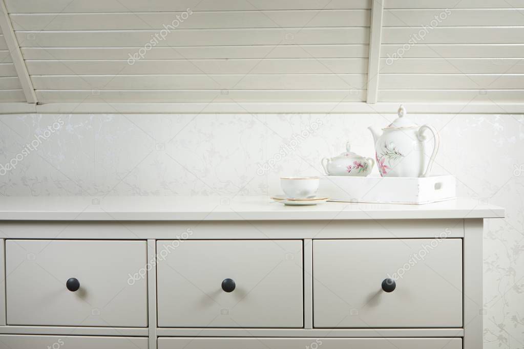 White tea service on white commode ready for use. Start a morning with cup of tea or coffee.