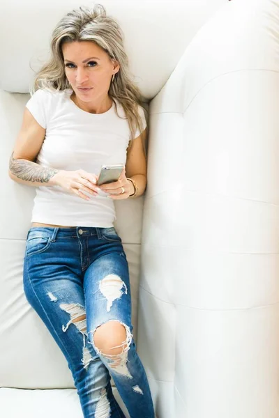 Young woman in jeans using smart phone - Top view