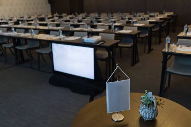 Boş konferans salonu, ön plan, monitör, sandalye ve masa beyaz bayrak.