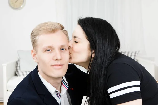 Young attractive businesswoman kissing man in formal dress.