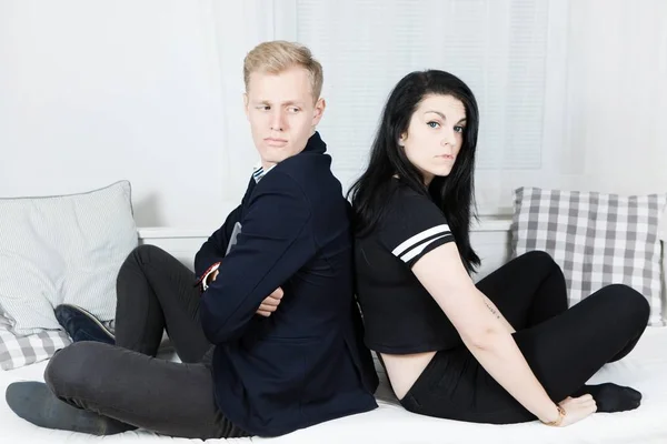 Young attractive business couple in love - sitting on bed back to back. — Stock Photo, Image