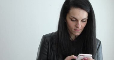 Kadın siyah deri ceketli cep telefonu, mavi gözlü, uzun siyah saçları mesaj gönderme