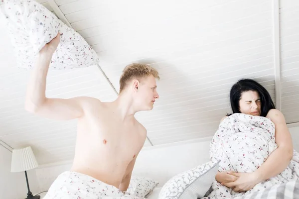 丈夫要用枕头打妻子--卧室里的暴力, 男人在床上打女人. — 图库照片