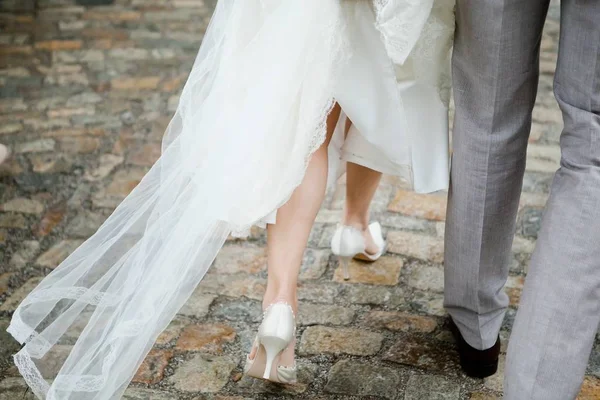 Bride and groom walking, details bride's on legs. — Stock Photo, Image