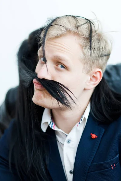 Blond man in formal dress - fake mustache from girlfriend\'s hairs.