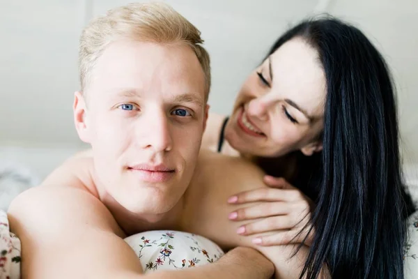 Schöner Mann und schöne Frau im Bett - junges verliebtes Paar — Stockfoto