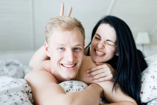 Schöner Mann und schöne Frau posieren im Bett - Hasenohren — Stockfoto