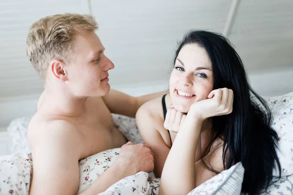 Przystojny mężczyzna zakochany w miłej kobiecie leżącej w łóżku — Zdjęcie stockowe