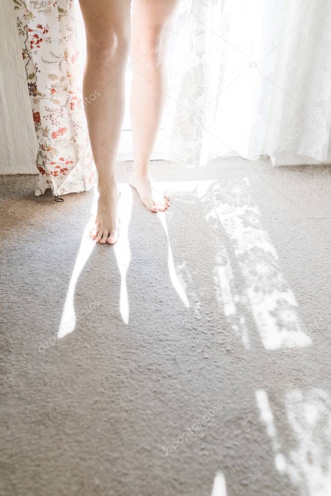 Woman's barefoot in window light.