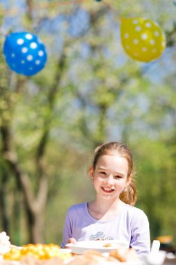 Doğum günü bahçe partisinde masaya oturan genç yaşlı kız