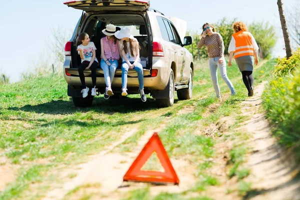 Un triangle de rupture se tient près d'une voiture cassée - de la route — Photo