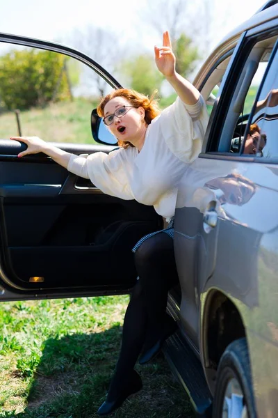 Une femme aux cheveux roux obtenant notre d'une voiture pour appeler de l'aide — Photo