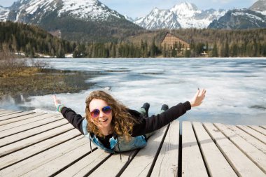 Genç kız donmuş dağlarda yatıyor. Strbske Gölü 'nün kenarında.