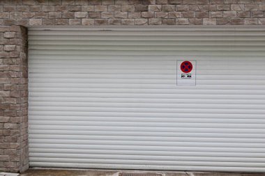 Park levhası olmayan beyaz garaj kapısı..