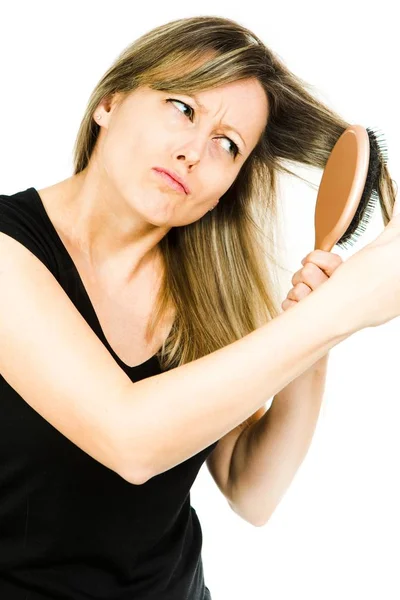 Ξανθιά γυναίκα που έχει πρόβλημα με το βούρτσισμα μακριά ευθεία μπλεγμένα μαλλιά με βούρτσα — Φωτογραφία Αρχείου