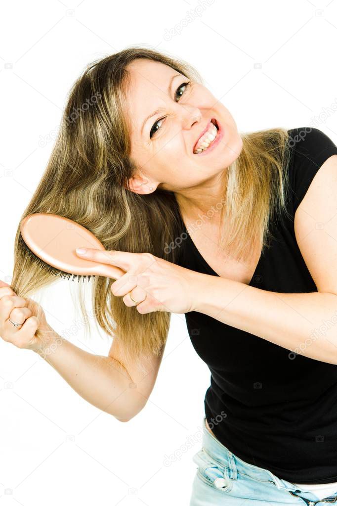 Blond woman having problem with brushing long straight tangled hair with hairbrush - hopeless situation.
