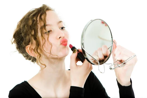 Έφηβος κορίτσι με μαύρο φόρεμα κάνοντας το μακιγιάζ σε στρογγυλό καθρέφτη-κραγιόν. — Φωτογραφία Αρχείου