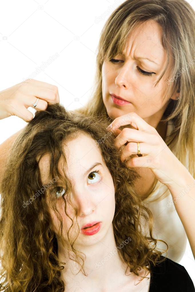 Mother checking child's head for lice - louse on head