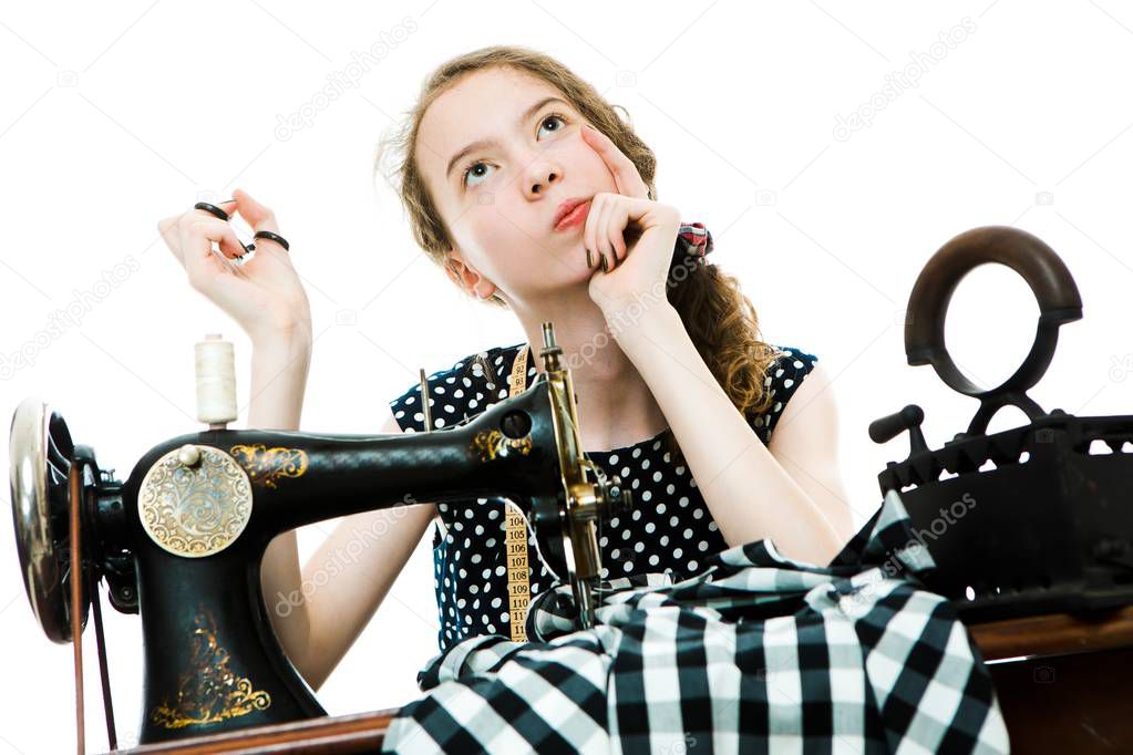 Teenaged girl dressmaker thinks and plan before will use manual sewing machine.