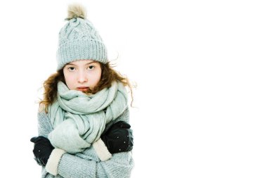 Genç kız kış şapkası ve eldiven giyerek kendini ısıtıyor..